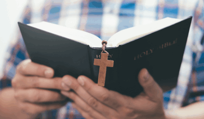An unidentified man holds and reads a Bible.