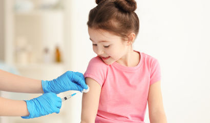 A doctor vaccinates a little girl in a clinic.