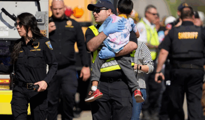 A first responder carries a boy after a school bus crash.